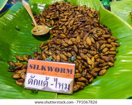 Fried silkworms for sale on a banana leaf at a market in Hua Hin, Thailand