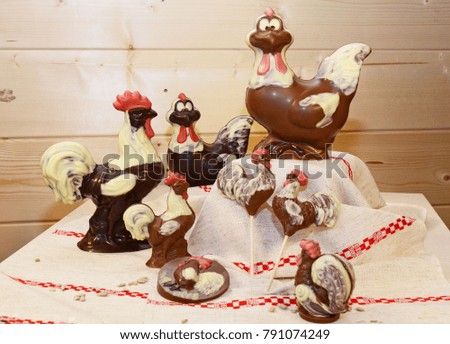 Chocolate chickens and cockerels on wooden background