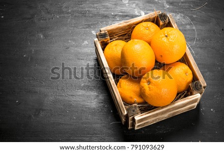 Fresh oranges in an old box. On the black chalkboard.