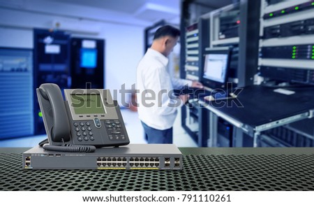 IP Telephone and Network switch 24 port gigabit and blur network administrator in data center room Royalty-Free Stock Photo #791110261