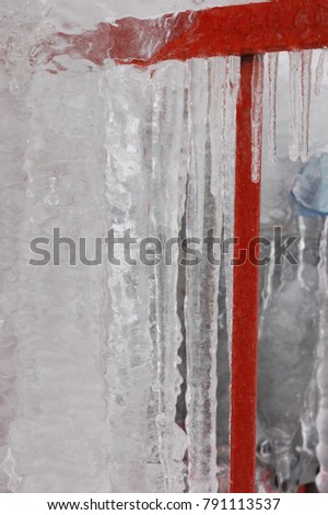 beautiful abstract icicles on red railing close up winter ice storm