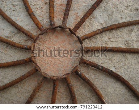 Rustic sun , Solar sign , rusty nails stacked in the form of the sun with rays , on 
the background of concrete.
