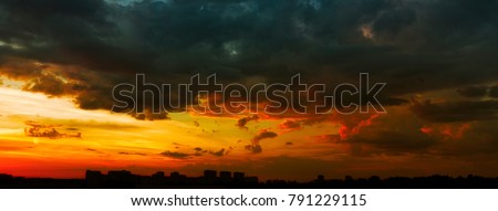 Panorama of a beautiful stormy sunset over the city in dramatic colors
