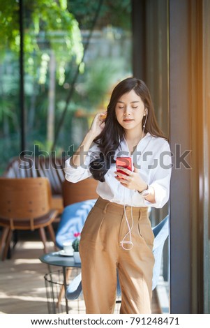 Portrait of beautiful asian woman listening to her music from Smartphone