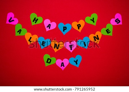 Happy Valentines Day message on multicolor hearts on red background. Valentines day concept
