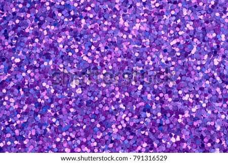 Glitter background. Purple sequins texture. Glow light effect.
