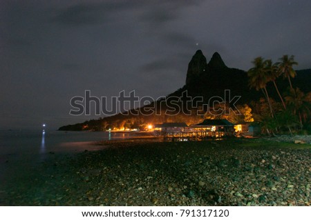 On the beach at night with Dragons Horns & village at background