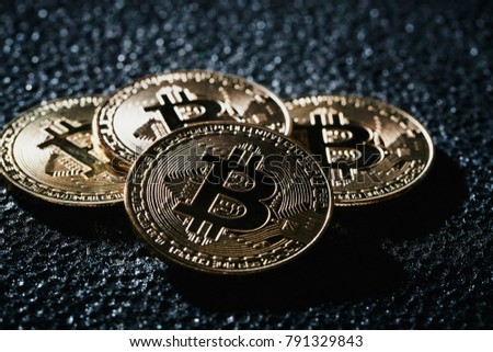 Golden bitcoin coin on the blackbackground.