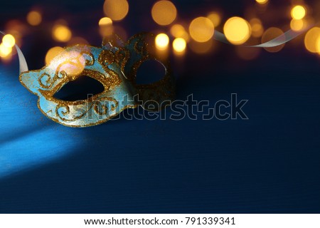 Image of elegant blue and gold venetian, mardi gras mask over blue background