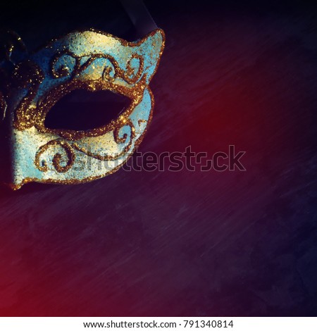 Image of elegant blue and gold venetian, mardi gras mask over black background