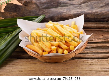 Fries fry in a basket on a wooden background. Royalty-Free Stock Photo #791354056