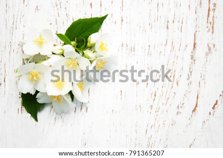 Border with jasmine flowers on a wooden background