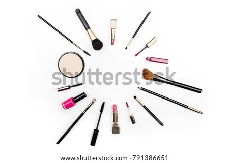 Makeup brushes, pencil, lipstick, and other objects, forming a frame on a white background, with copy space. A template for a makeup artist's business card or flyer design