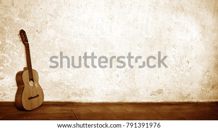 wide horizontal background with an old acoustic sepia guitar