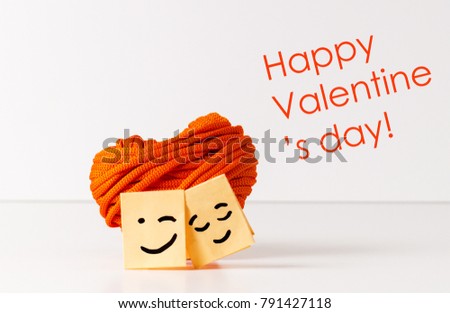 Miniature paper faces with heart shape object and text: Happy Valentine's day!