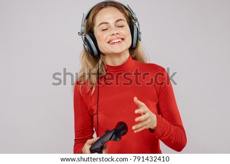  cheerful woman with headphones in hands joystick on light background                              