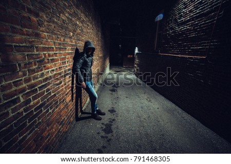 Suspicious man in dark alley waiting for something Royalty-Free Stock Photo #791468305