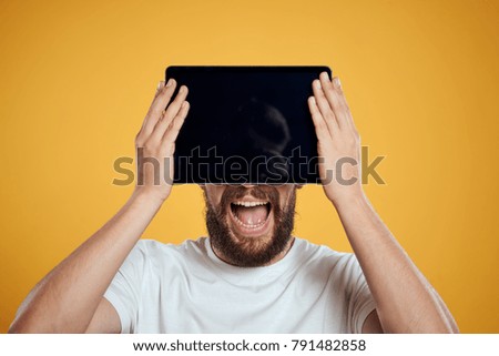  joyful man with a tablet on a yellow background                              