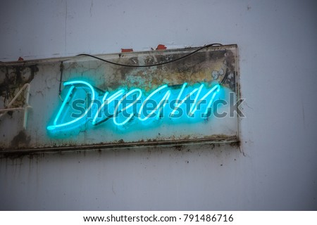 Blue neon sign Dream on a grimy wall of London street