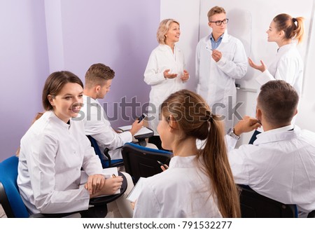 Happy positive  medical students communicating during recess between lectures in auditorium