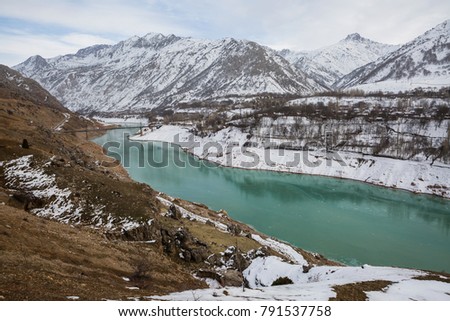 Landscape with snowy mountains and a turquoise river.Uzbekistan