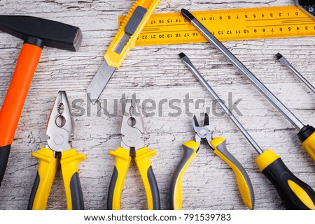 On a wooden background the layout of various construction tools. Top view.
