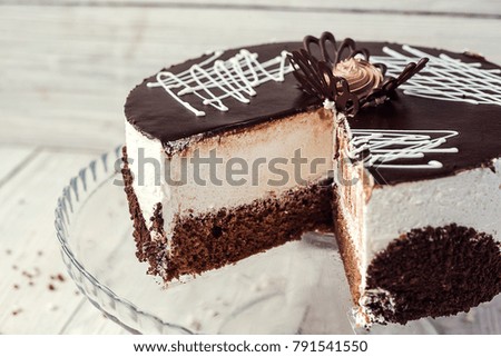 dark chocolate vegan cake with cream on wooden background