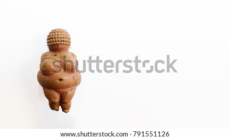 Venus of Willendorf statuette, exact copy of the original. Ancient motherhood and fertility symbol. White background with space for letters. Wide format 16x9