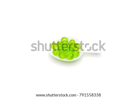 Soft gelatin capsules Spherical Green of vitamin E (alpha tocopherol) in plastic tea spoon isolated on white background with copy space for add text. Royalty-Free Stock Photo #791558338