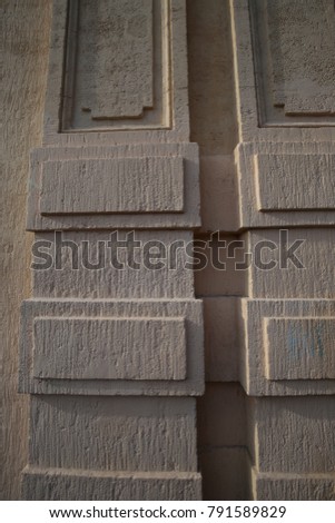 Abstract view of the facade of a brown stone wall made of bricks. Pattern composed with lines and blocks. Relief and shadow make a textured material surface. Picture taken in South of France on 2018. 
