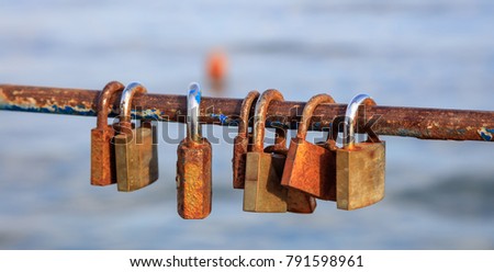 Rusty padlocks locks on peeled railing. Tradition for couple in love. Blur backdrop, closeup, detail