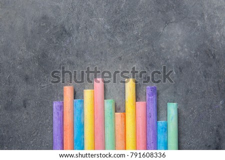 Bottom Rows of Multicolored Chalks Crayons on Dark Stone Blackboard Background. Business Creativity Graphic Design Crafts Kids School Unity Concept. Copy Space