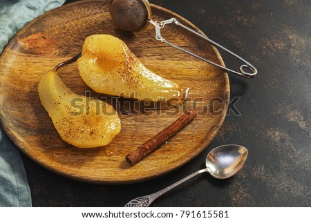Pear dessert pashot. Pear caramelized in syrup on a wooden plate.