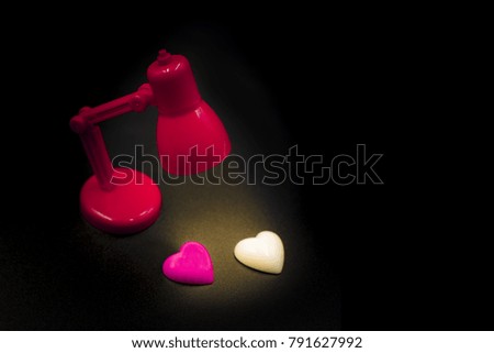 Valentine's day 2 heart under the lamp , present as couple under the light for fulfill together. open space for text on black background