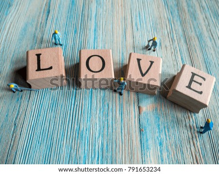 Selective focus image of miniature working on  wood text love,abstract background to valentine concept. / with copy space