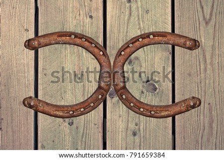 Old rusty horseshoe on wood background. Good luck symbol. Western feeling.