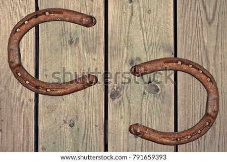 Old rusty horseshoe on wood background. Good luck symbol. Western feeling.