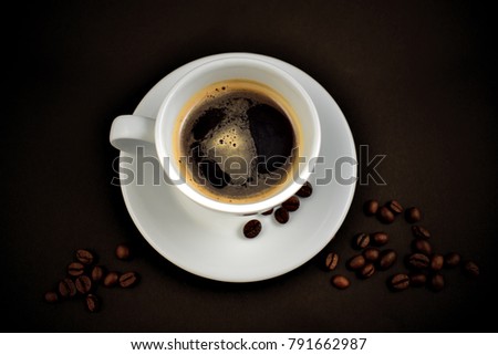 White cup of coffee stock images. White cup of coffee on a black background. Cup of coffee with coffee beans