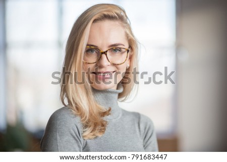 portrait of a smiling young caucasian woman wearing glasses Royalty-Free Stock Photo #791683447