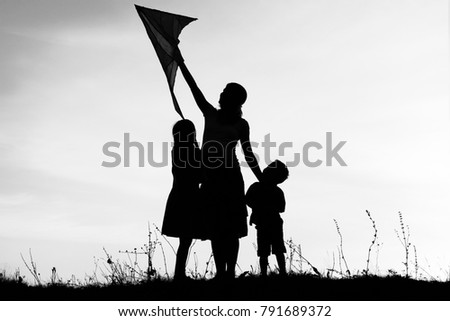 Happy parent with children playing on nature summer silhouette