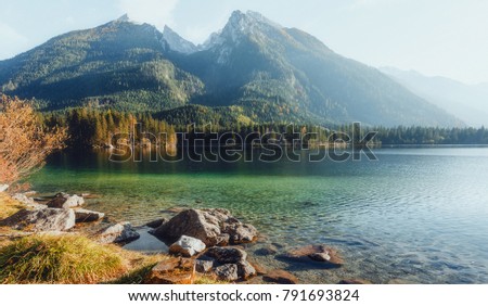 Majestic alpine Mountain in sunny day. Unsurpassed sunrise in the mountains. Majestic azure lake Under Sunlight. wonderful picturesque Scene. Amazing Highmountain Lake Hintersee. Bavaria. Alps