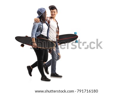 Full length profile shot of teenage skaters with longboards talking with each other and walking isolated on white background