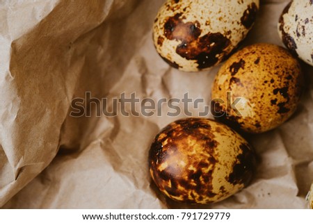 Easter quail eggs on craft paper and rustic burlap background. Easter eggs on craft paper and burlap fabric texture. Spring background with small easter quail eggs. Vintage photo processing