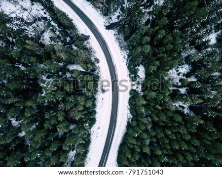 Aerial Drone Photography of a Road in Winter, Between Woods with a Snow on a cloudy Winter Day