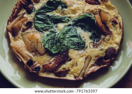 Italian Frittata with slices of fresh greens and potatoes. Food film styled photo.
