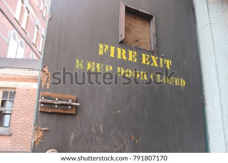 Fire exit sign in interior of old abandoned mental asylum hospital building
