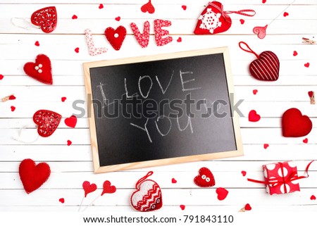 Blackboard with  confession and hearts on white wooden background. Valentine's day concept. Flat lay, top view.