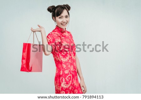 Asian woman holding shopping bag, woman wear cheongsam, chinese new year