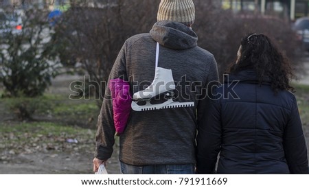 couple with a white skate on the back walk in a park