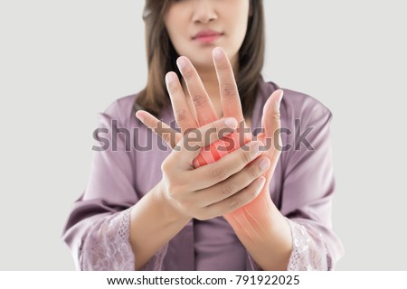 Asian woman suffering from pain in bone against gray background, Concept with hand arthritis grimace in pain